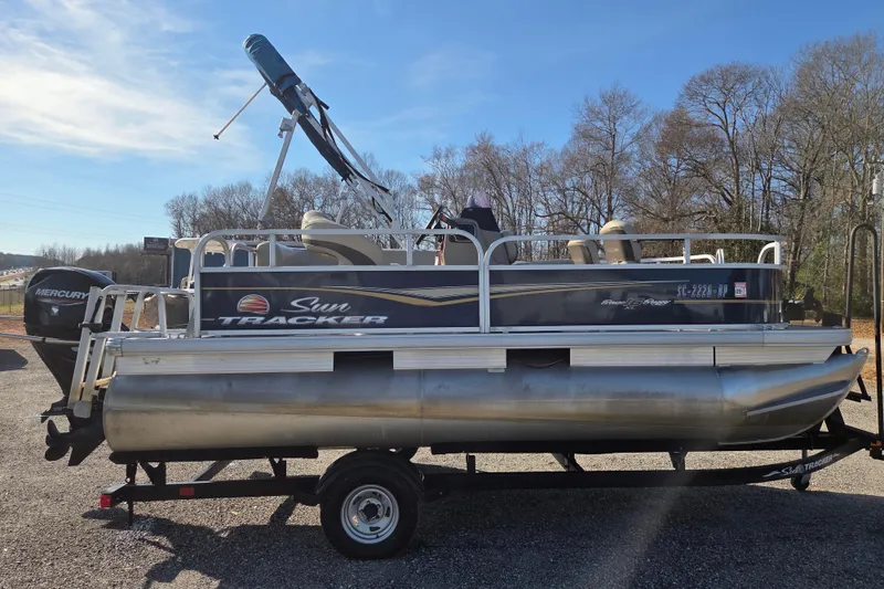 Slide: The Image of 2021 Sun Tracker Bass Buggy 16 XL pontoon boat on trailer, outdoor setting. - 4