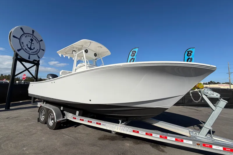 Slide: The Image of 2013 Regulator 24 Forward Seating boat on trailer under clear blue sky. - 0