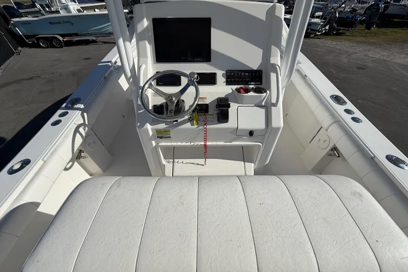 Slide: The Image of 2013 Regulator 24 Forward Seating boat at a marina under clear blue skies. - 13