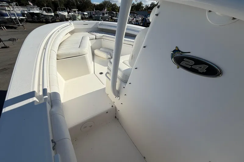 Slide: The Image of 2013 Regulator 24 Forward Seating boat interior with white cushioned seating and storage compartments. - 18