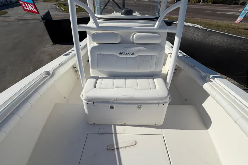 Slide: The Image of 2013 Regulator 24 Forward Seating boat cockpit with steering wheel and controls. - 24