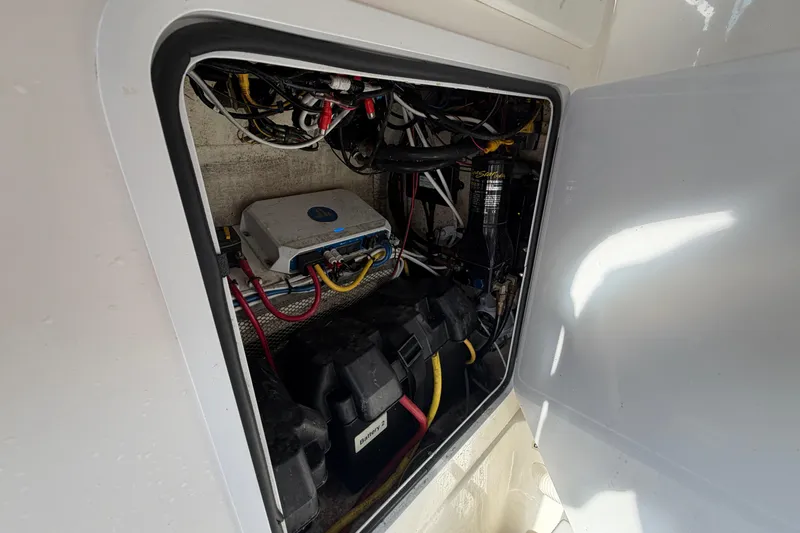 Slide: The Image of 2013 Regulator 24 Forward Seating boat in a marina, surrounded by other boats and vehicles. - 52