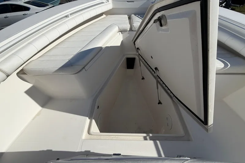 Slide: The Image of 2013 Regulator 24 Forward Seating boat interior, showcasing storage compartment and seating area. - 56