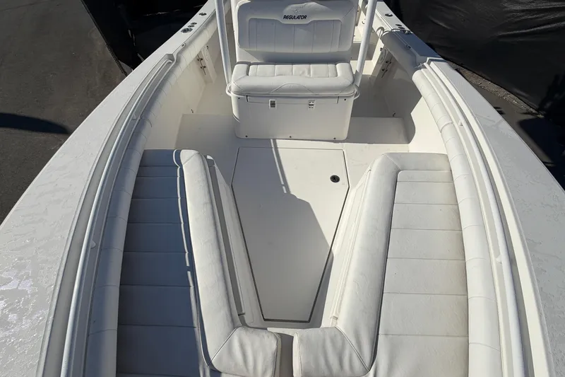 Slide: The Image of 2013 Regulator 24 Forward Seating boat with T-top and speakers, parked outdoors. - 71