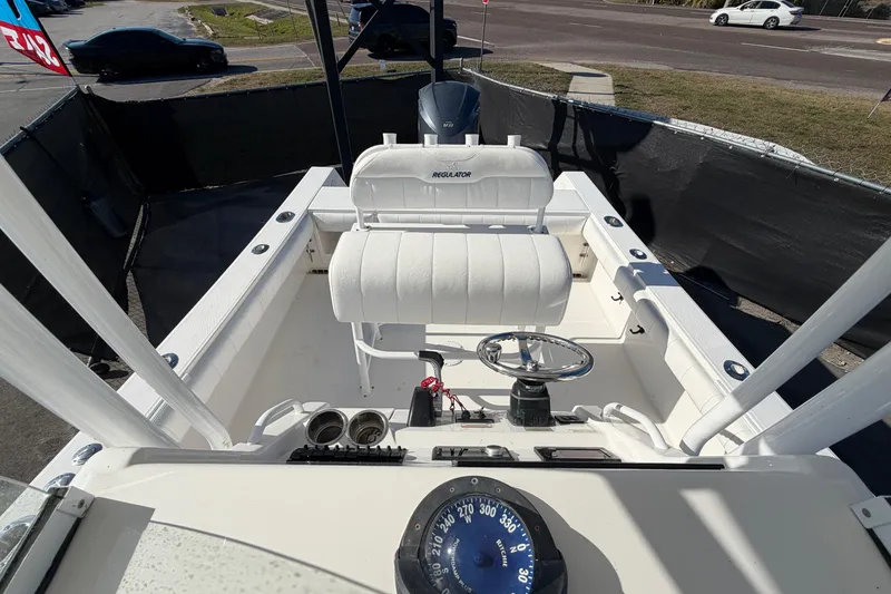 Slide: The Image of 2013 Regulator 24 Forward Seating boat with white cushioned seats. - 77