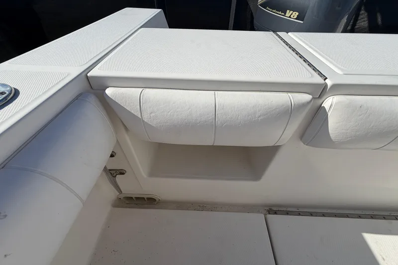 Slide: The Image of 2013 Regulator 24 Forward Seating boat interior with white seating and storage area. - 81