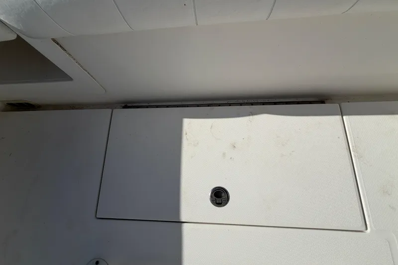 Slide: The Image of 2013 Regulator 24 Forward Seating boat compartment with visible plumbing components. - 84