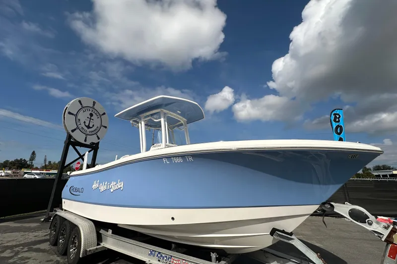 The Image of 2024 Robalo R232 Explorer boat on trailer under blue sky. - 0
