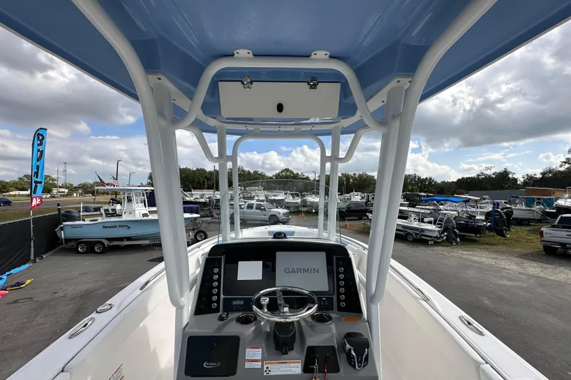 Slide: The Image of 2024 Robalo R232 Explorer boat dashboard with Garmin display at a dealership. - 13