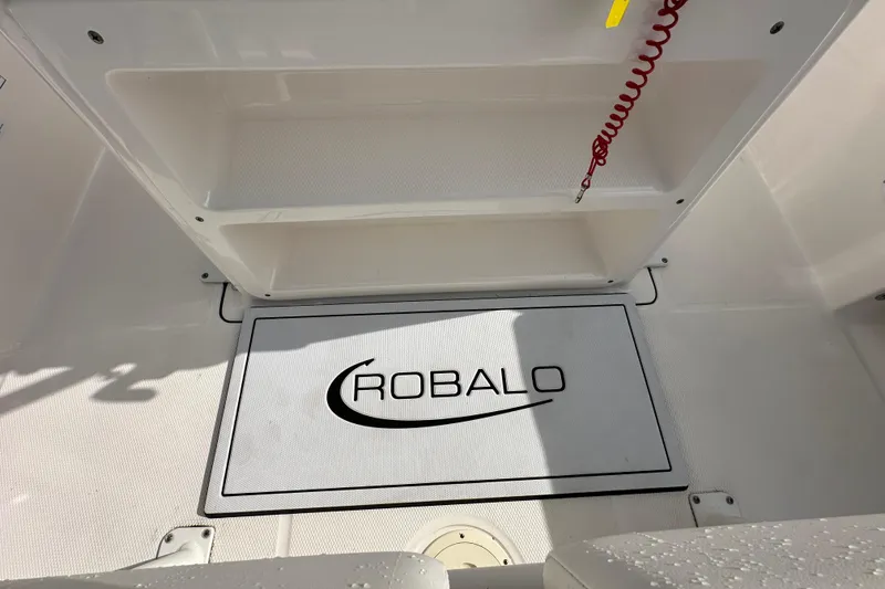 Slide: The Image of 2024 Robalo R232 Explorer boat deck with logo and storage compartment. - 17