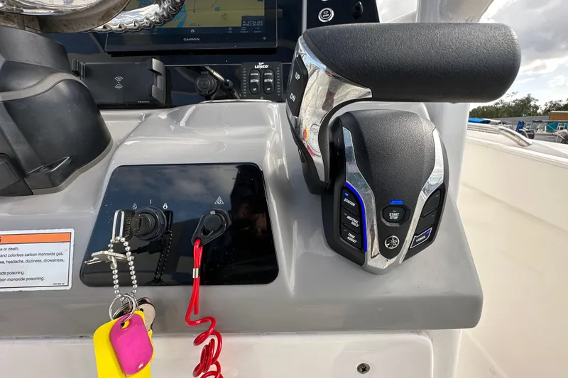 Slide: The Image of 2024 Robalo R232 Explorer boat dashboard with control panel and throttle lever. - 24