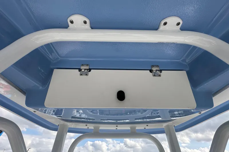 Slide: The Image of 2024 Robalo R232 Explorer boat roof storage compartment with blue and white design. - 26