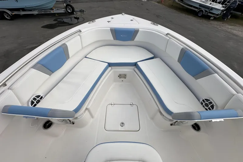 Slide: The Image of 2024 Robalo R232 Explorer boat interior with white and blue cushioned seating. - 28
