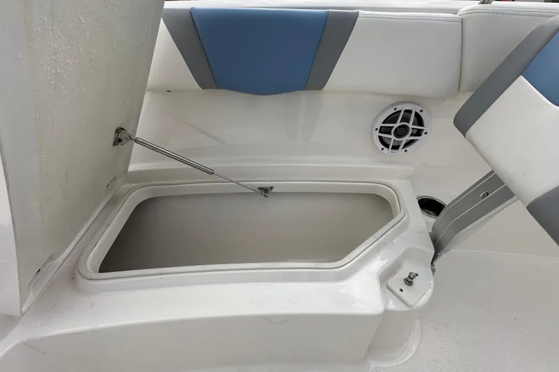 Slide: The Image of 2024 Robalo R232 Explorer boat storage compartment with open hatch and speaker. - 33