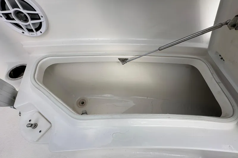 Slide: The Image of 2024 Robalo R232 Explorer storage compartment with open lid and speaker detail. - 34