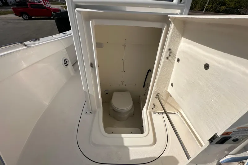 Slide: The Image of 2024 Robalo R232 Explorer boat interior with compact marine toilet. - 40