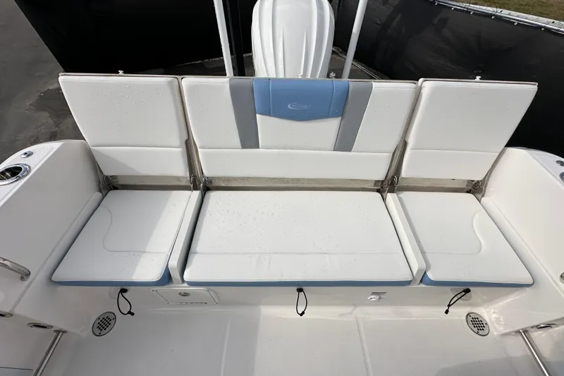 Slide: The Image of 2024 Robalo R232 Explorer boat seating area with white cushions and blue accents. - 45
