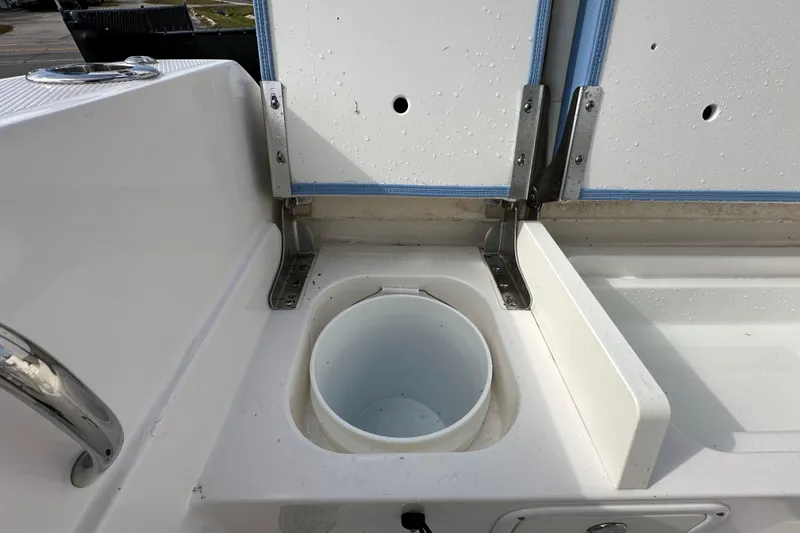 Slide: The Image of 2024 Robalo R232 Explorer boat storage compartment with open lid and bucket. - 48