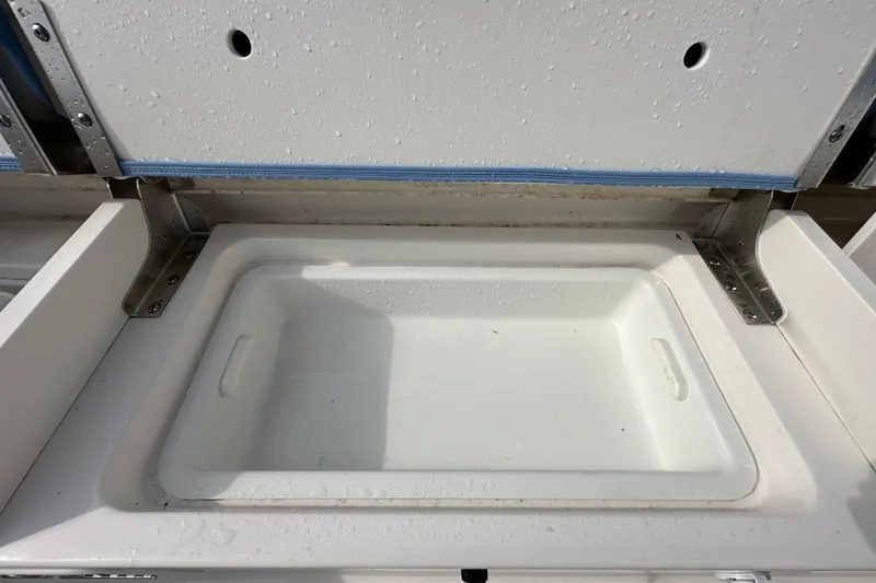 Slide: The Image of 2024 Robalo R232 Explorer boat storage compartment with stainless steel hinges. - 49