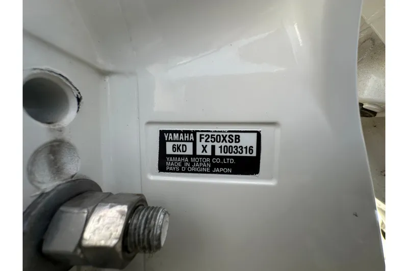 Slide: The Image of 2024 Robalo R232 Explorer boat deck with storage compartment and engine details. - 56