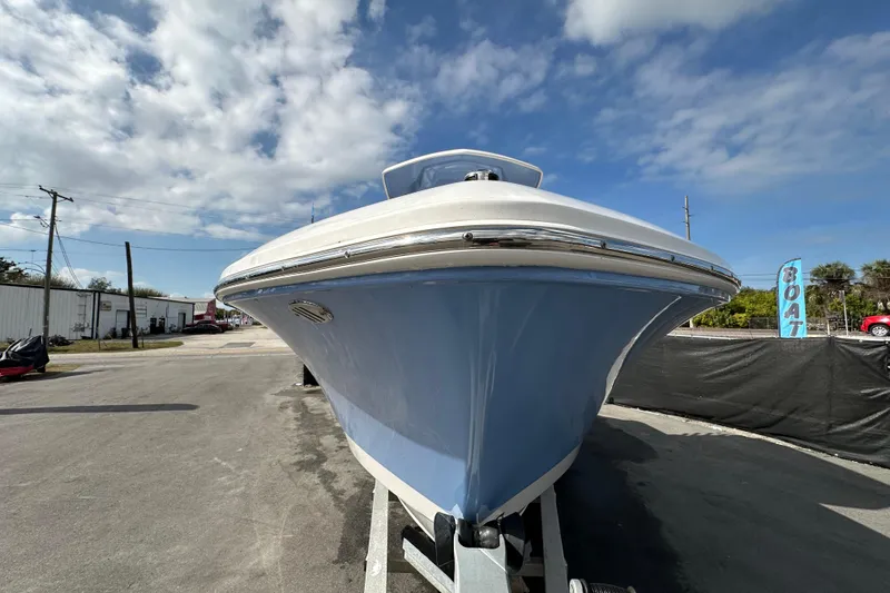 Slide: The Image of 2024 Robalo R232 Explorer boat on trailer under a partly cloudy sky. - 7