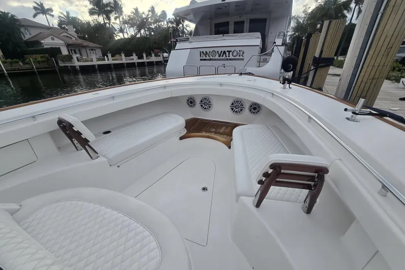 Slide: The Image of 2021 Valhalla Boatworks V-46 with white seating, docked by a waterfront. - 21