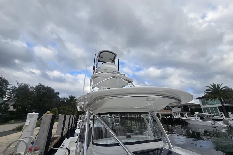 Slide: The Image of 2021 Valhalla Boatworks V-46, sleek white interior, docked by waterfront homes. - 27