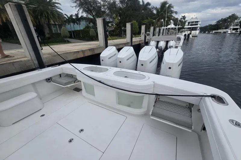 Slide: The Image of 2021 Valhalla Boatworks V-46 docked beside a larger yacht and parked vehicles. - 38