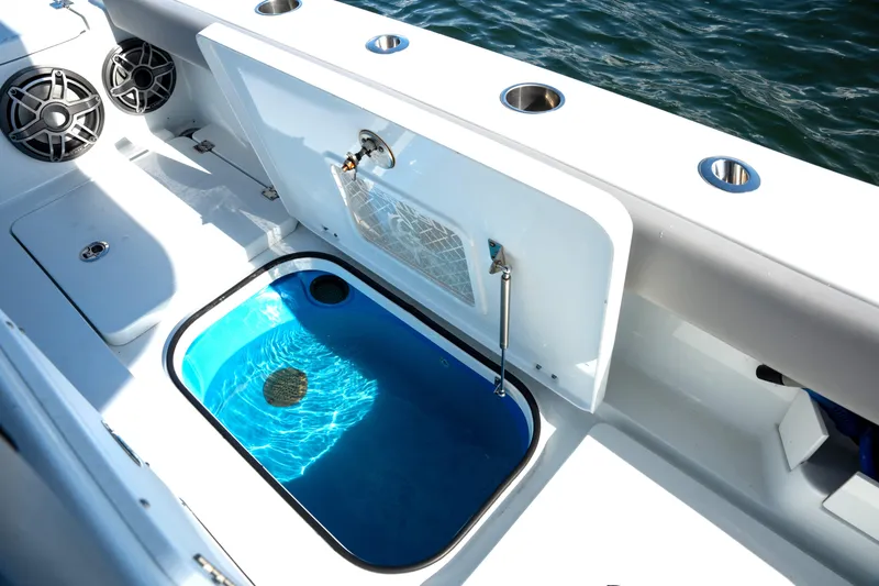 Slide: The Image of 2024 Freeman 28 boat interior with livewell and speakers, docked on water. - 11