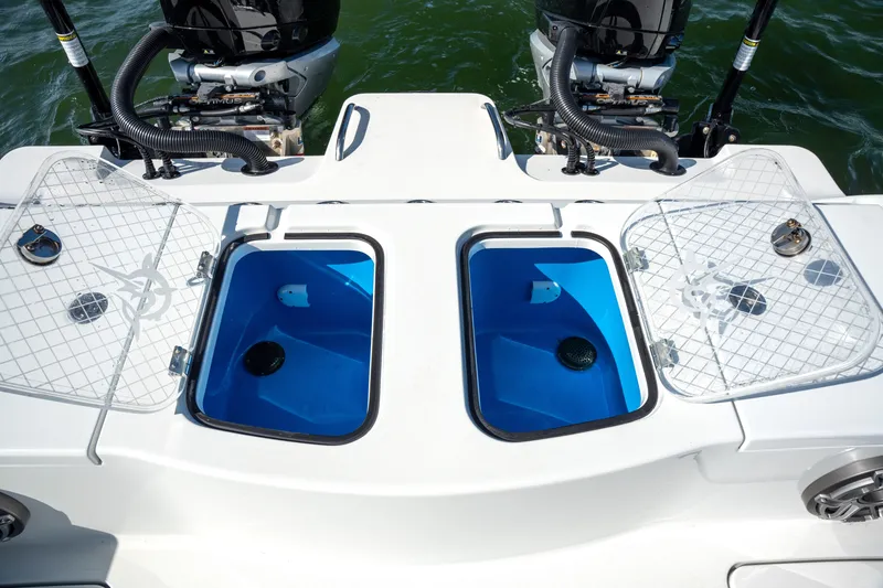 Slide: The Image of 2024 Freeman 28 boat with open livewells and dual outboard motors. - 13