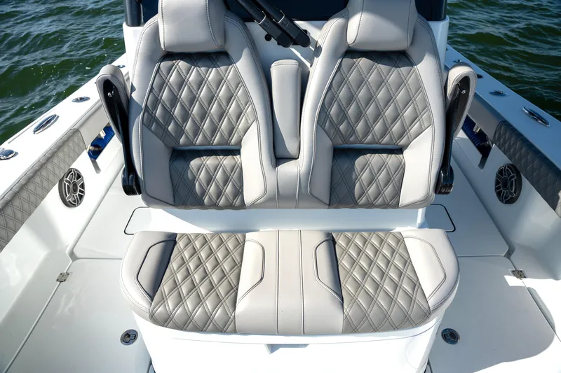 Slide: The Image of 2024 Freeman 28 boat interior with diamond-stitched seats on water. - 14