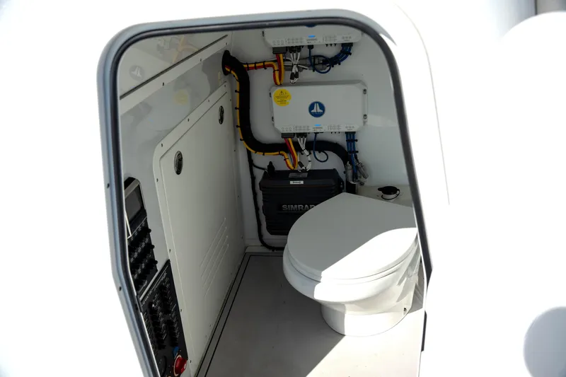 Slide: The Image of Interior of 2024 Freeman 28 boat showing compact marine toilet and electrical systems. - 17