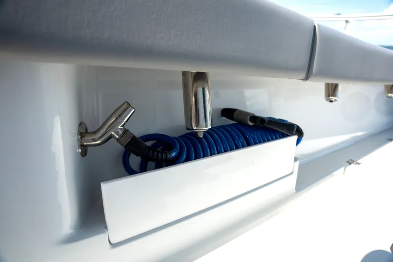 Slide: The Image of Freeman 28 boat detail, 2024 model, featuring a coiled blue hose and faucet. - 21