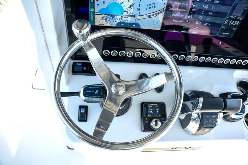 Slide: The Image of Steering wheel and controls of 2024 Freeman 28 boat with navigation display. - 26