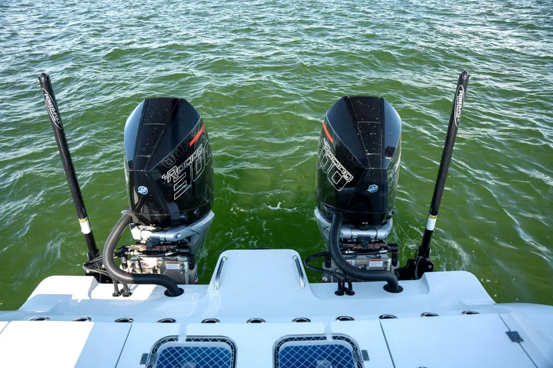 Slide: The Image of Twin outboard motors on a 2024 Freeman 28 boat in green water. - 31