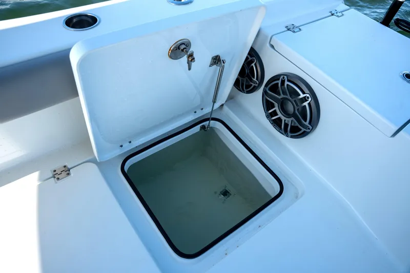 Slide: The Image of Open storage compartment on Freeman 28 boat, featuring speakers and cup holders, 2024 model. - 9