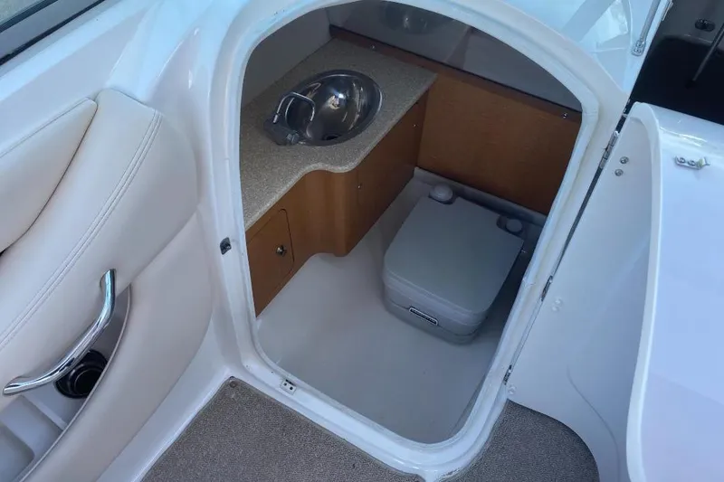 Slide: The Image of 2006 Chaparral 256 SSi boat interior with sink and portable toilet. - 8