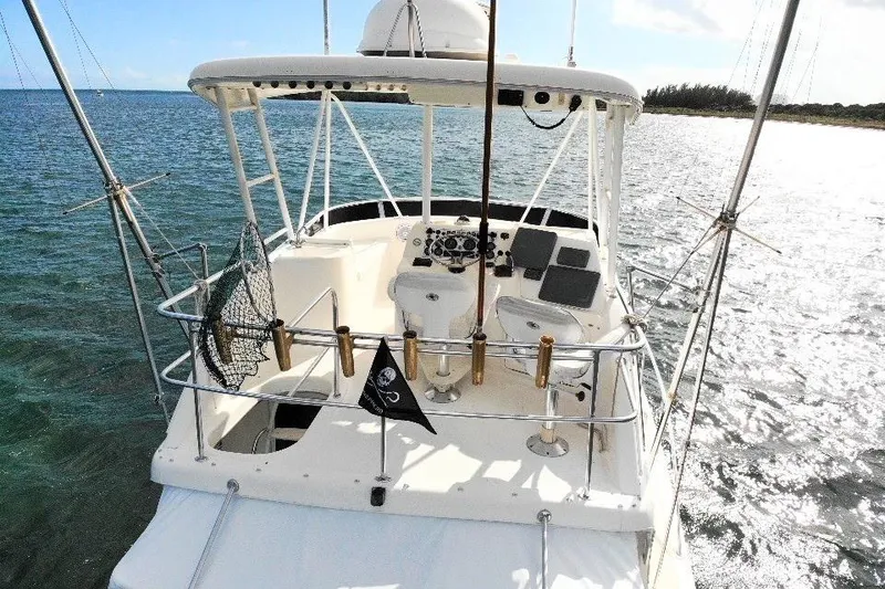 Slide: The Image of 1999 Wellcraft 400 Coastal boat on water, featuring fishing gear and helm station. - 10