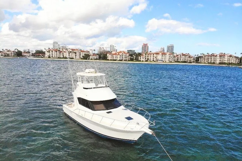 Slide: The Image of 1999 Wellcraft 400 Coastal yacht on blue water with cityscape background. - 11