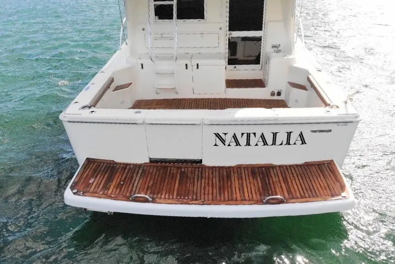 Slide: The Image of 1999 Wellcraft 400 Coastal boat named "Natalia" with wooden deck on water. - 14