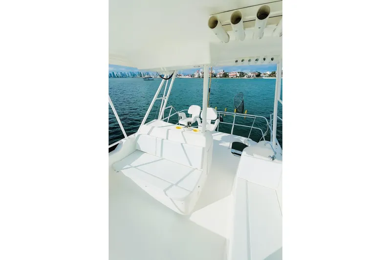 Slide: The Image of 1999 Wellcraft 400 Coastal boat interior with seating, overlooking calm waters and distant shoreline. - 24