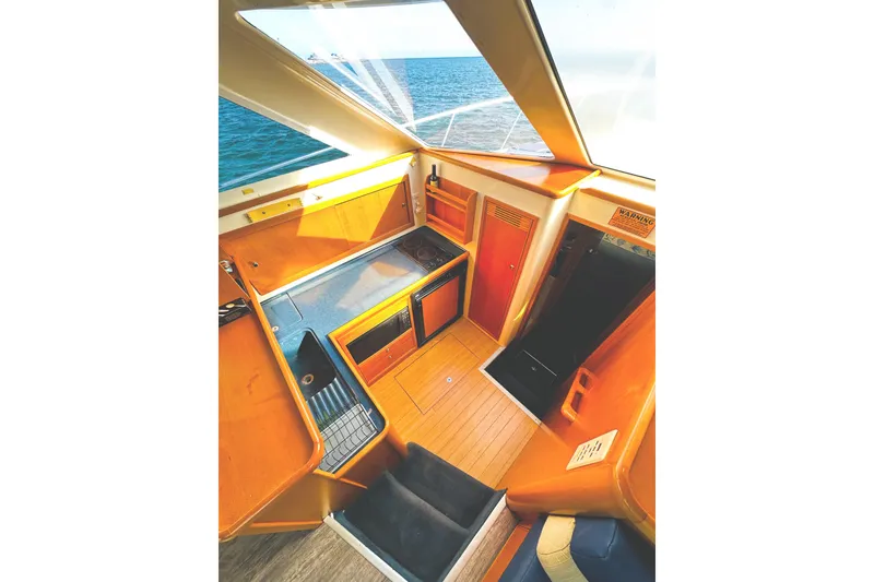 Slide: The Image of Interior of 1999 Wellcraft 400 Coastal boat with wooden cabinetry and ocean view. - 27