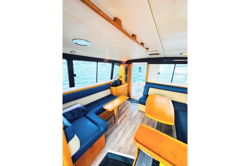 Slide: The Image of Interior of 1999 Wellcraft 400 Coastal boat with blue seating and wooden accents. - 28