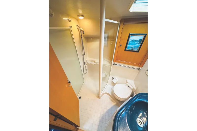 Slide: The Image of 1999 Wellcraft 400 Coastal yacht bathroom with shower, toilet, and sink. - 29