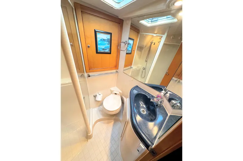 Slide: The Image of 1999 Wellcraft 400 Coastal yacht bathroom with modern fixtures and elegant wood accents. - 30