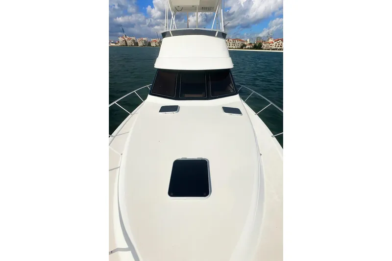 Slide: The Image of 1999 Wellcraft 400 Coastal boat on water, clear sky, cityscape in background. - 34