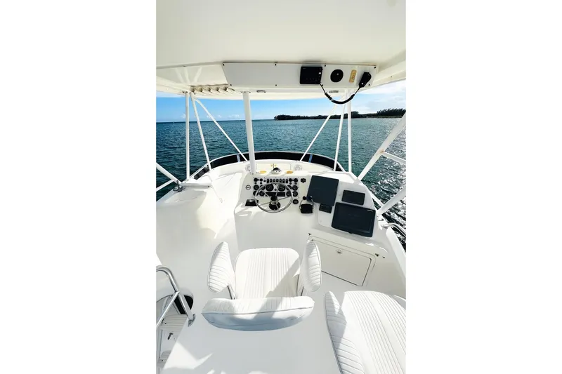 Slide: The Image of 1999 Wellcraft 400 Coastal boat helm with ocean view, featuring navigation equipment and seating. - 7