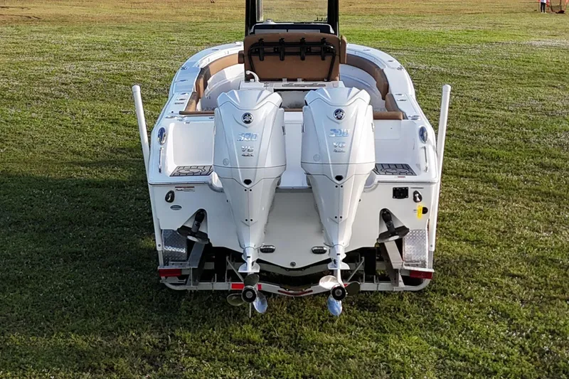 Slide: The Image of 2023 Seahunt 30 GameFish Coffin Box boat with dual outboard engines on grass. - 14