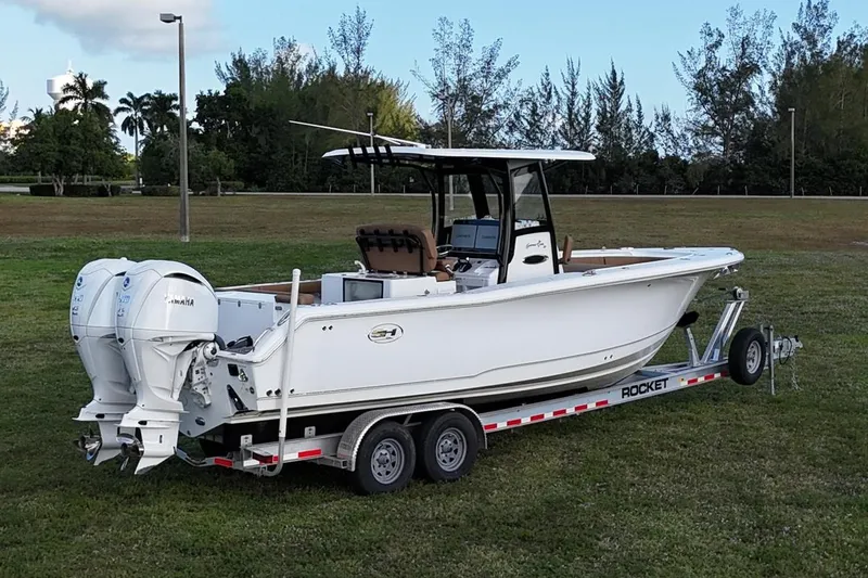 Slide: The Image of 2023 Seahunt 30 GameFish Coffin Box boat on trailer, parked on grass. - 2