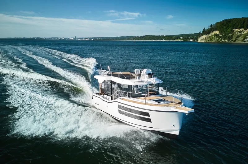 Slide: The Image of Modern Northman 1050 yacht cruising on open water, 2025 model, with scenic coastline backdrop. - 3